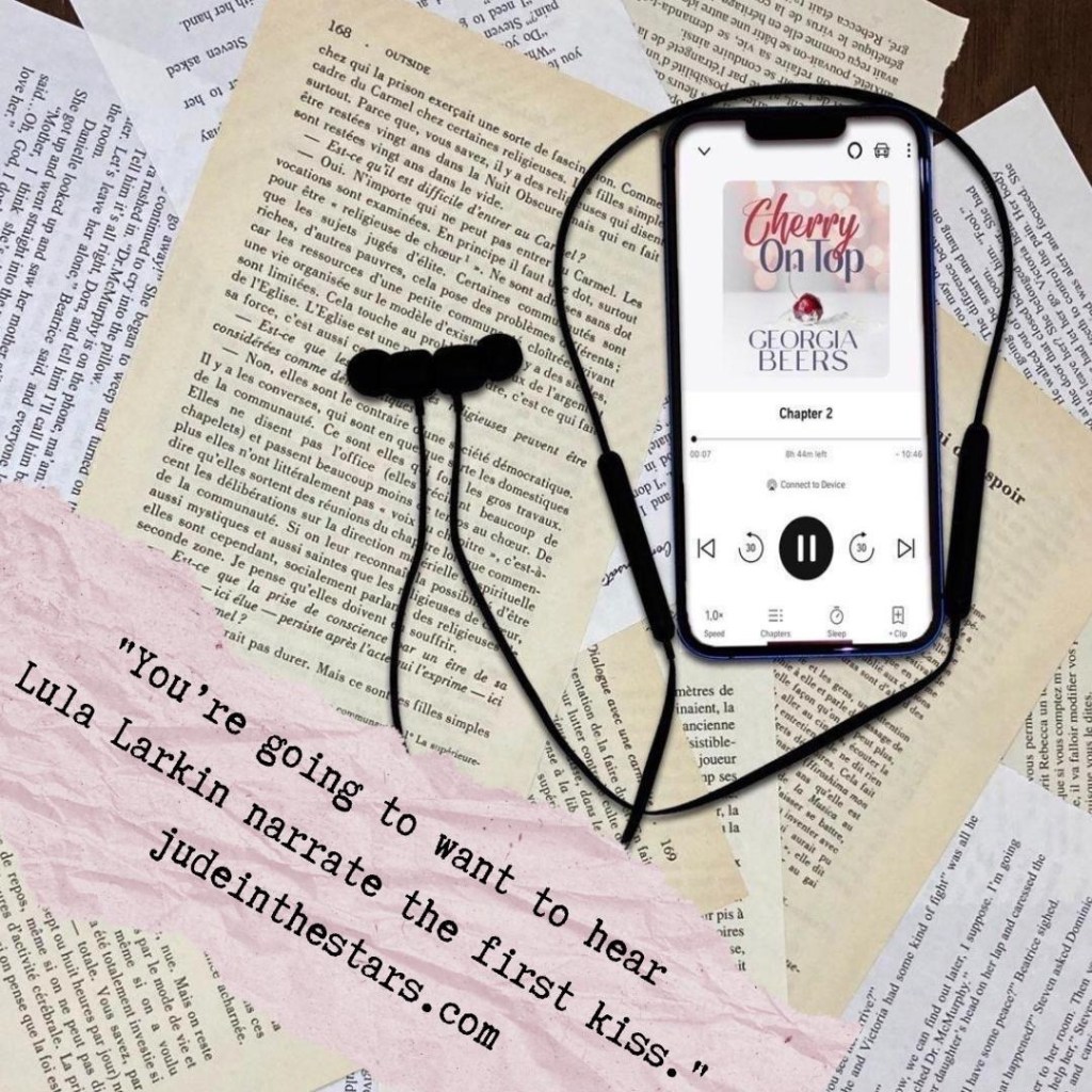 On a backdrop of book pages, an iPhone with the cover of the audiobook of Cherry on Top by Georgia Beers, narrated by Lula Larkin. At the bottom of the image, a pink strip of torn paper with a quote: "You’re going to want to hear Lula Larkin narrate the first kiss." and a url: judeinthestars.com.