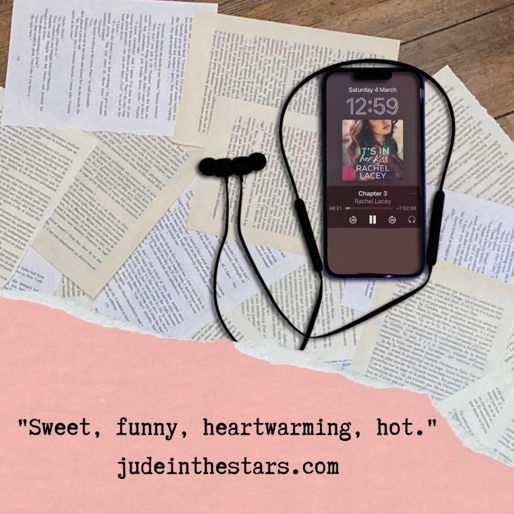 On a backdrop of book pages, an iPhone with the cover of It's In Her Kiss Her by Rachel Lacey, narrated by Lori Prince. At the bottom of the image, a strip of torn paper with a quote: "Sweet, funny, heartwarming, hot." and a URL: judeinthestars.com.