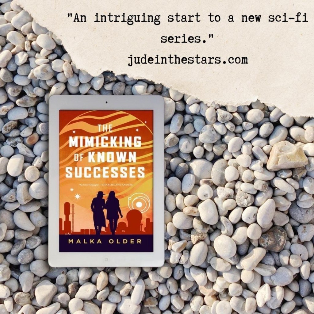 On a backdrop of book pages, an iPad with the cover of The Mimicking of Known Successes by Malka Older. At the top of the image, a strip of torn paper with a quote: "An intriguing start to a new sci-fi series." and a URL: judeinthestars.com.