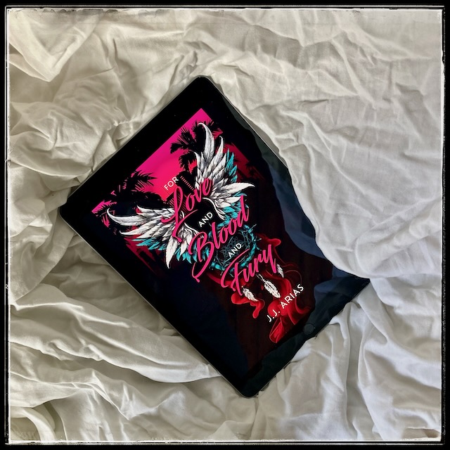 An iPad with the cover of For Love and Blood and Fury by JJ Arias on creased white sheets.